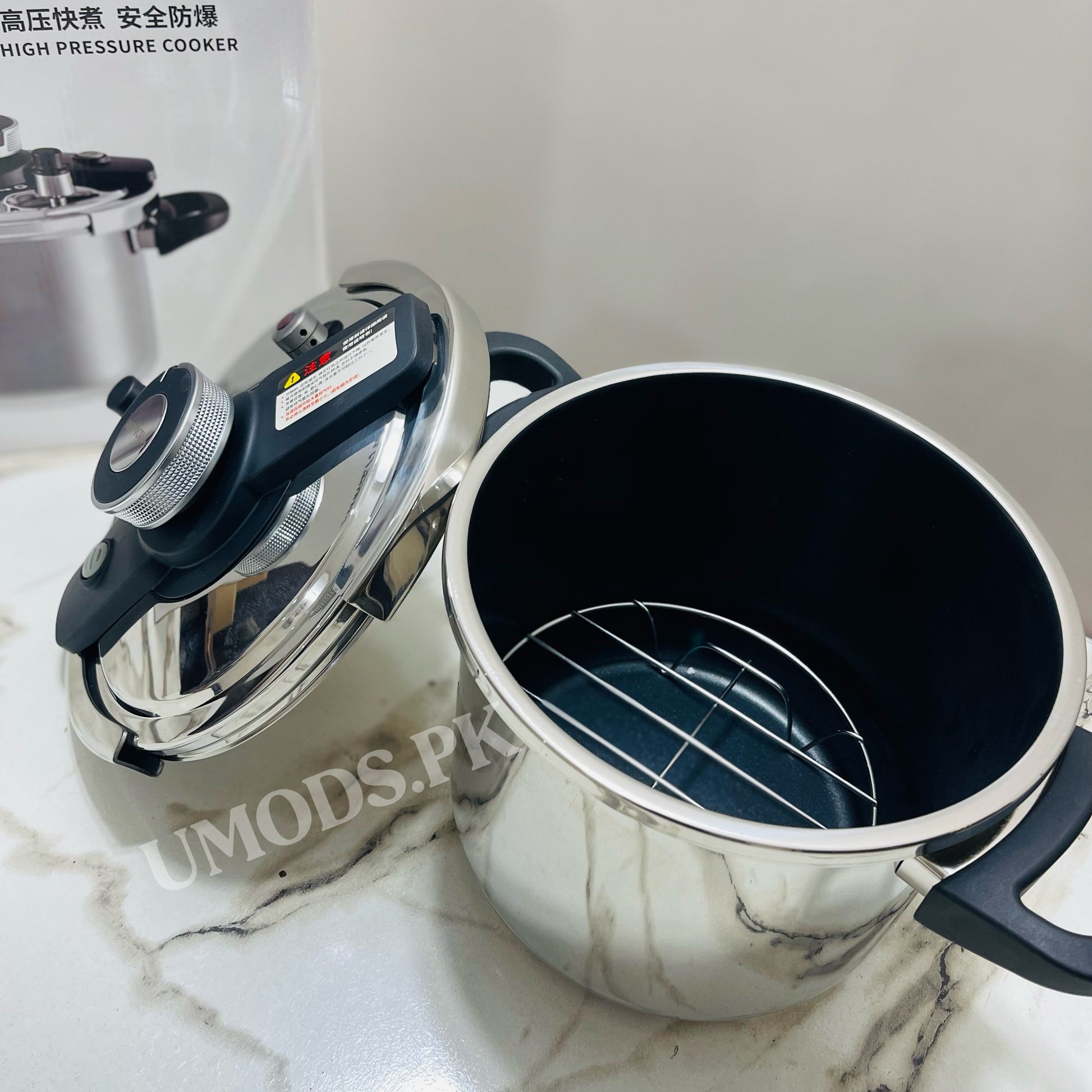 Pressure cooker on a marble surface with visible branding.